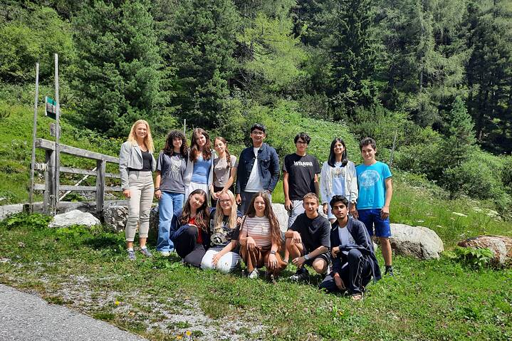 Eine kleine Gruppe posiert vor einer Bergkulisse.
