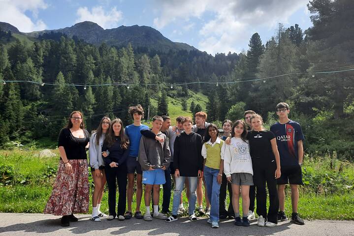 Eine kleine Gruppe posiert vor einer Bergkulisse.