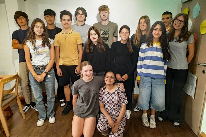 Eine kleine Gruppe posiert für ein Gruppenbild in einem Klassenraum.