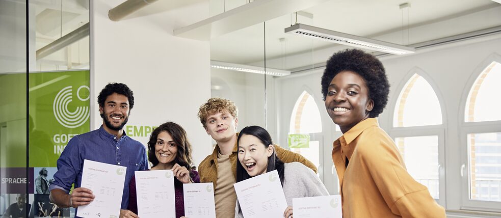 Partnerschule Die Prüfungsteilnehmenden haben die Prüfung bestanden. Sie sind glücklich und zeigen stolz ihre Goethe-Zertifikate.