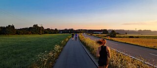 Jugendliche joggen im Sonnenaufgang.