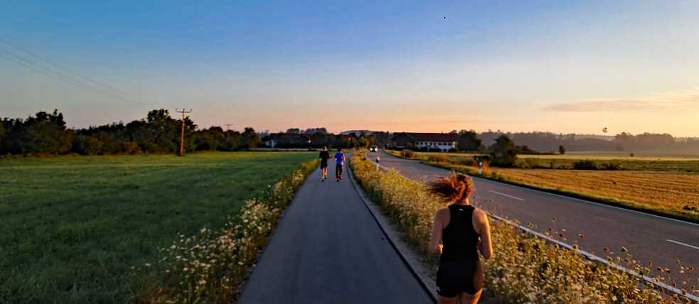 Jugendliche joggen im Sonnenaufgang.