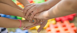 Kindliche Hände liegen aufeinander.