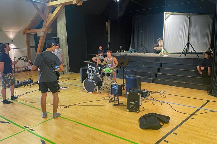 Jugendliche an Schlagzeug und E-Gitarre in einer Sporthalle