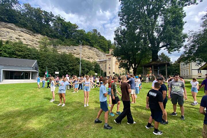 Jugendliche spielen auf einer Wiese. Sie haben sichtlich viel Spaß.