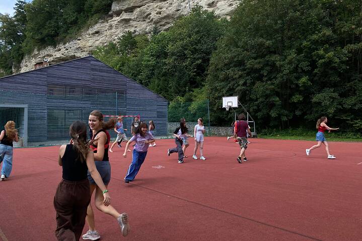 Jugendliche spielen auf einem Sportplatz. Sie haben sichtlich viel Spaß.