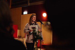 Laura Mangels stands on a stage.