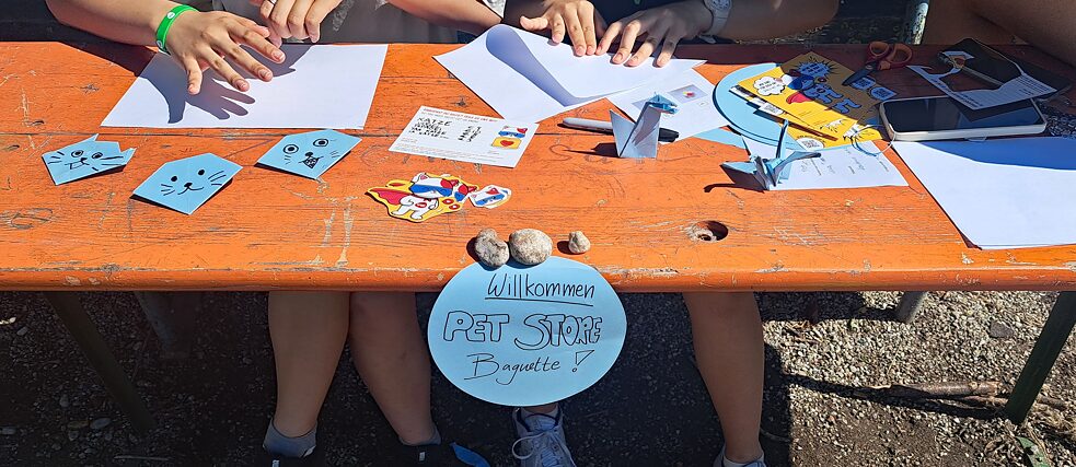 Jugendliche basteln an einem Biertisch.