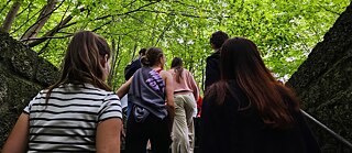 Jugendliche auf einer steinernen Treppe im Wald
