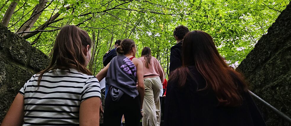 Jugendliche auf einer steinernen Treppe im Wald