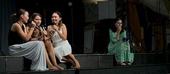 Zwei Jugendliche singen ins Mikrophon, eine sitzt etwas abseits und hält ein Handy.