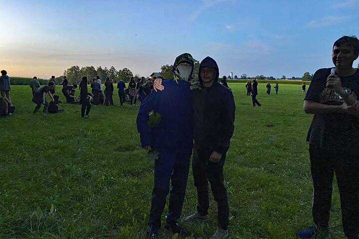 Jugendlich in Tarnkleidung oder schwarz gekleidet auf einer Wiese