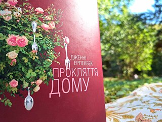 Книжка стоїть на простирадлі, позаду неї видно дім. 