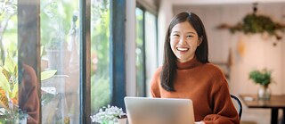 Female student with a laptop at a desk