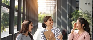 3 female friends standing in corridor