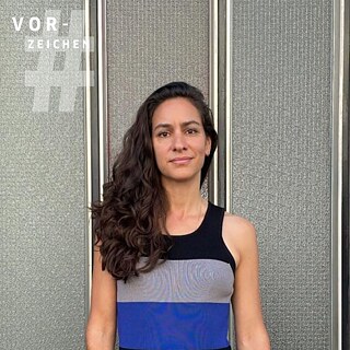 Auf dem Bild ist die Literaturkritikerin Maryam Aras zu sehen, sie trägt ein ärmelloses Oberteil mit grauen, blauen und schwarzen Blockstreifen.