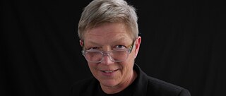 Portrait of a women with short gray hair and glasses