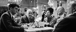 Başaktör Jan Bülow, bir dans gecesinde dört kişiyle birlikte- üç erkek ve bir kadın- bir masada oturuyor. Derin bir sohbete dalmış durumdalar. Siyah beyaz bir fotoğraf.