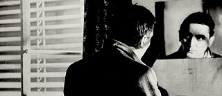 Schwarzweißbild eines Mannes der in den Spiegel guckt