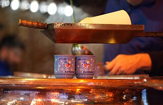 An employee at the Christmas market in Hamburg-Wandsbek fills a mug with Feuerzangenbowle.