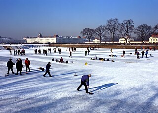 Curling on the frozen lake in front of Nymphenburg Palace in Munich