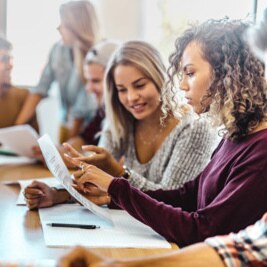 Zwei junge Frauen diskutieren über einen Text