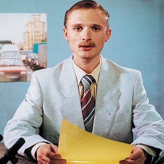 Denis (Florian Lukas) gibt sich als Nachrichtenreporter aus