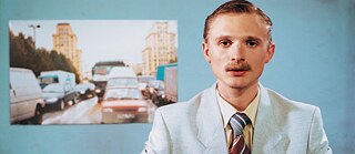 Denis (Florian Lukas) gibt sich als Nachrichtenreporter aus