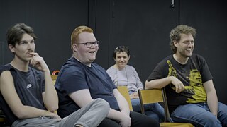 Eine Gruppe sitzender lächelnder Leute