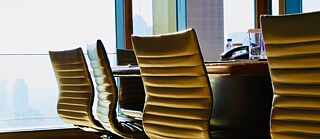 A row of empty, modern office chairs around a conference table by large windows. © © Pixabay Interactive Workshop - Make a Great Impression