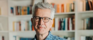 Mann mit Brille und grauen Haaren