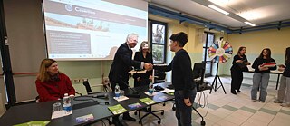 Ein Schüler überreicht den Gästen Buchgeschenke 