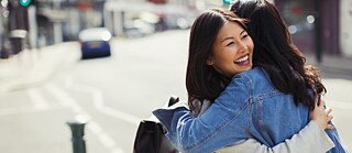 Dua wanita saling berpelukan.