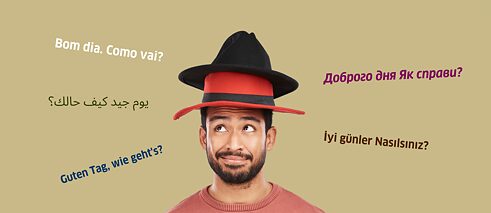 Mann mit zwei Hüten auf dem Kopf und mehreren Sprachen im Hintergrund