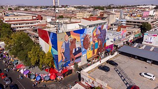 Um das Wandgemälde herum befinden sich eine Reihe von formellen und informellen Ständen.