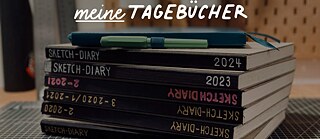 Ein Stapel Notizbücher mit Stiften oben drauf