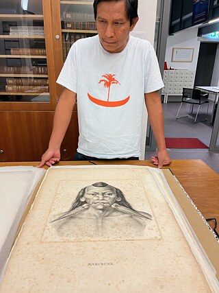 João Paulo Lima Barreto betrachtet eine Lithografie aus dem Atlas zur Reise in Brasilien von Martius und Spix