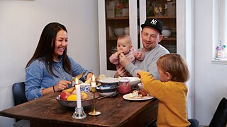 Familie sitzt am Esstisch