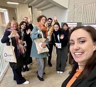 A group of people smile and pose for a photo together in a building.