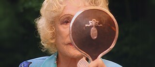 Die gealterte Leni Riefenstahl in Nahaufnahme vor einen Handspiegel