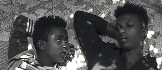 Zwei Jungen liegen auf einem Teppich