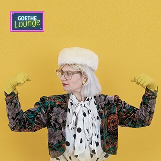 A singer with strong arms in front of a yellow background