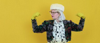 A singer with strong arms in front of a yellow background