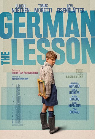 Movie poster for “The German Lesson”: A boy holding a slate under his arm looks back seriously. He wears a wool sweater, shorts, and rubber boots. The background features large blue text with the film title and actor names.