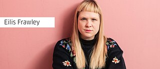 Eilis Frawley vor einem pinken Hintergrund