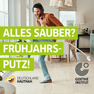 Ein Mann fegt mit einem Besen, hört dabei Musik und tanzt.