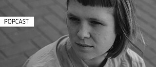 Eine junge Frau (Eilis Frawley) blickt nachdenklich zur Seite. Wort "Popcast"