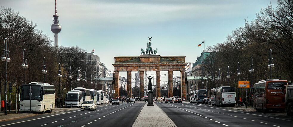 Street view of the Brandenburg Gate in Berlin with light traffic and the TV Tower in the background