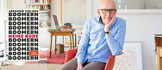 Heinz Bude sitzt auf einem Stuhl und stützt seinen Kopf mit seiner linken Hand