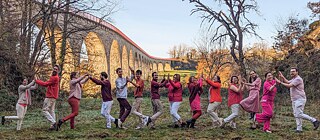 Un groupe de personnes se tienne les mains et sourit à la caméra